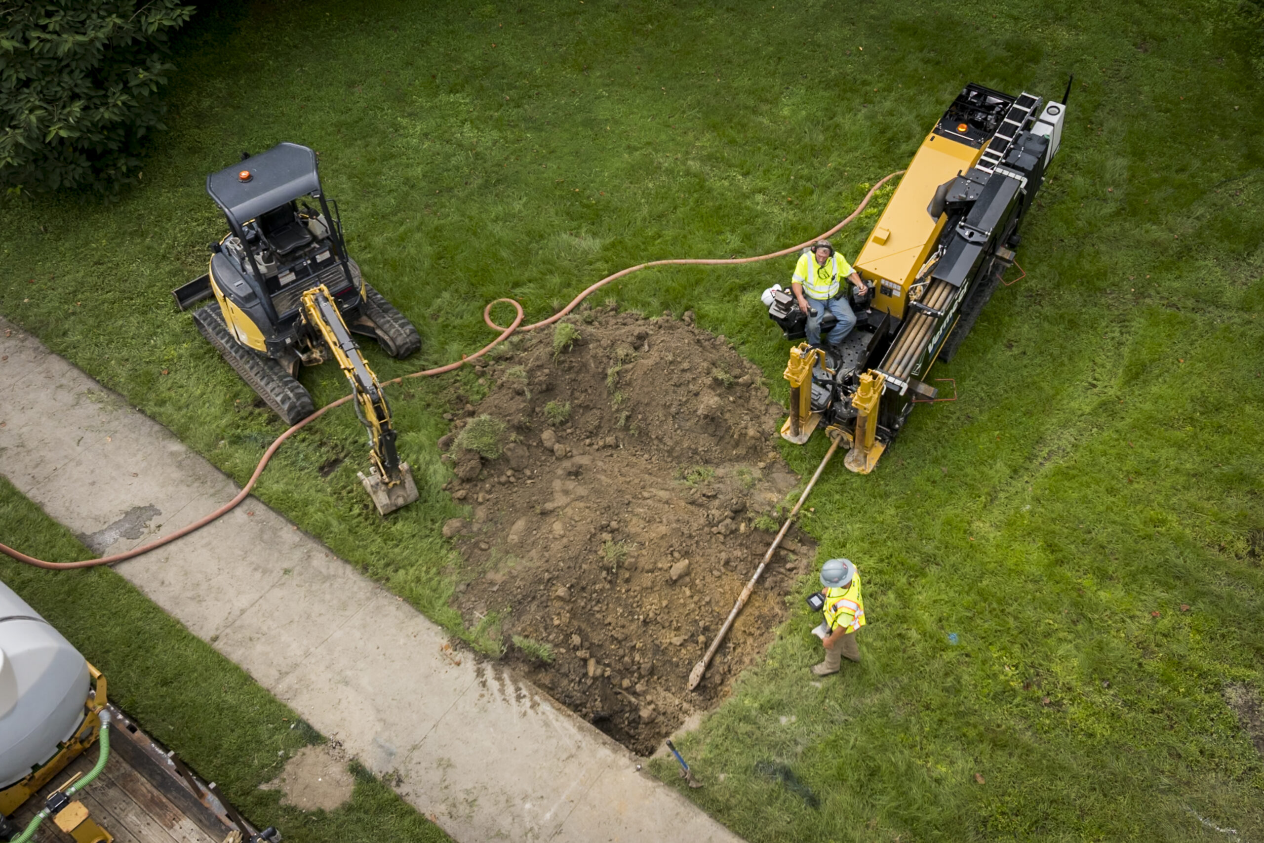 Directional Drill and Mini Excavator on a green patch of grass 