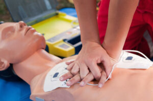Practicing the defibrillator CPR procedure on a dummy.